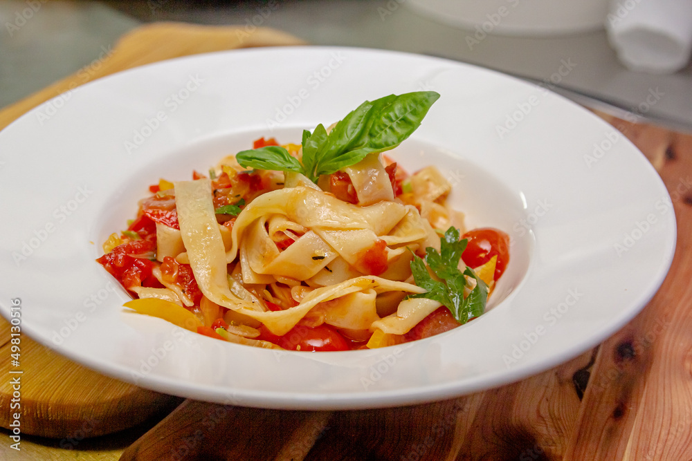 Wall mural Pappardelle or Linguini pasta in tomato sauce lies on a plate