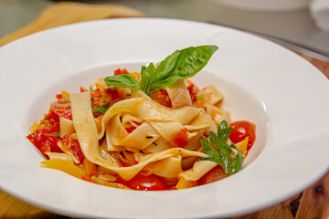 Pappardelle or Linguini pasta in tomato sauce lies on a plate