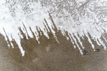 Asphalt cleaning foam with long lines. White and gray