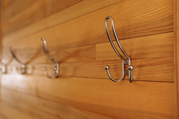 Stainless steel hooks for clothes at wooden wall