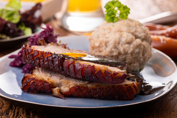 portion of fresh roasted pork on a blue plate