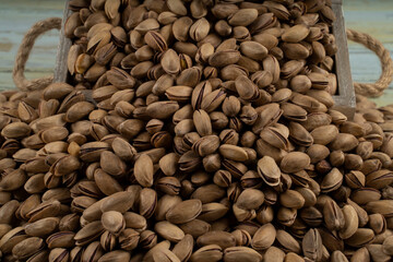 Pistachio in a wooden rustic chest; composition of pistachios great for healthy and dietary nutrition. Concept of nuts