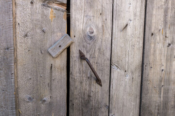 closed door with iron handle. door closed with a wooden catch