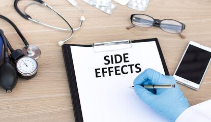 Side Effects text is written by a doctor on a piece of paper on a table, a medical concept
