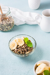 Boiled quinoa mix with banana and mint in a bowl on the table. Homemade healthy breakfast.