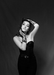 Naklejka premium black and white portrait. Sexy girl in a black corset and gloves