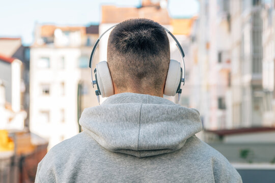 Head Of Young Man With Headphones On His Back In The Street