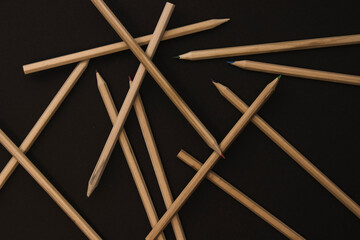 Many wooden pencils on the black background