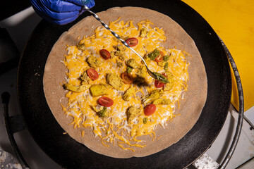 Chicken and cheese crepe cooking on hot plate