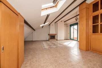 Pine carpentry in cabinets and stairwell cladding in a single-family home with a habitable attic with a fireplace and access to a terrace with green aluminum and glass doors