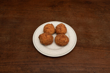 Delicious round croquettes of fresh cheese and ham tacos on a circular plate served in a Spanish tapas restaurant