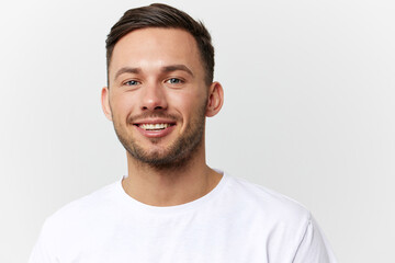 Joyful cute happy young tanned handsome man in basic t-shirt laugh at camera posing isolated on over white studio background. Copy space Banner Mockup. People emotions Lifestyle concept. Portrait