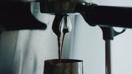 Espresso machine making fresh coffee. Pouring coffee stream from machine in steel cup. Espresso in...