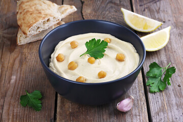 Hummus traditional oriental vegan sauce from chickpea on wooden background. Healthy food. Selective focus