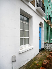 part of building with white wall and blue door