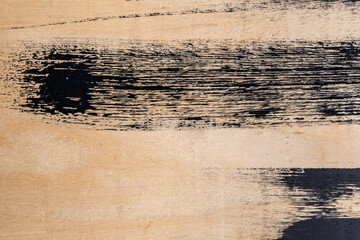 detalle de mancha de pintura negra horizontal sobre madera con textura áspera