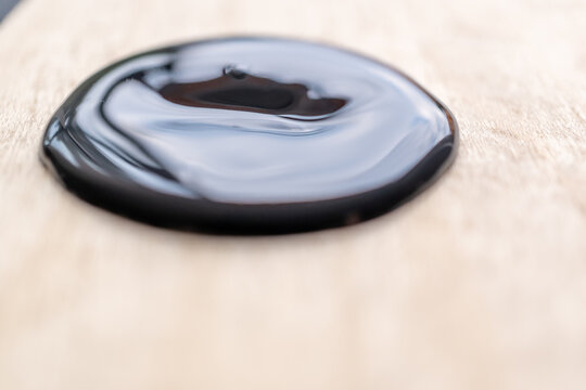 detalle de plasta de pintura negra acr&iacute;lica con poca profundidad de campo, sobre madera de pino