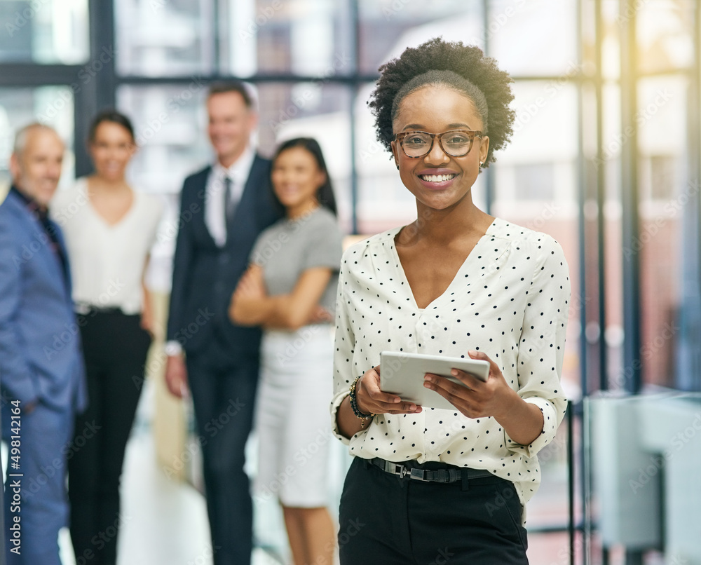 Canvas Prints Shes leading the team on their embark to success. Portrait of a young businesswoman holding a digital tablet with her colleagues in the background.