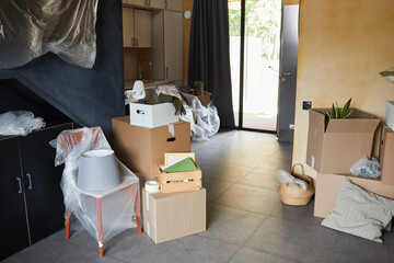 Background image of messy cardboard boxes in new home, family moving and relocation concept, copy space