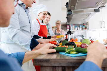 People learning healthy cooking in a training kitchen with a chef