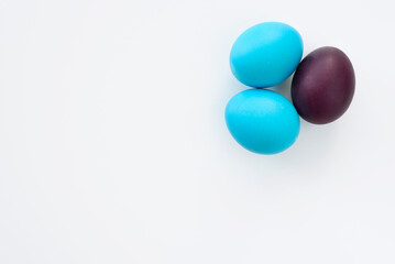 Blue and violet easter eggs, lying on a white background, with copy space. Easter concept.