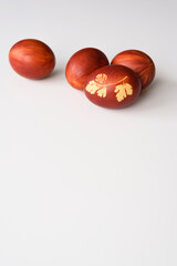 Easter eggs, lying on a white background. Painted brown, with a plant theme. Easter concept.