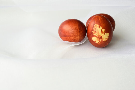 Easter eggs, lying on a white background. Painted brown, with a plant motif. Easter concept.