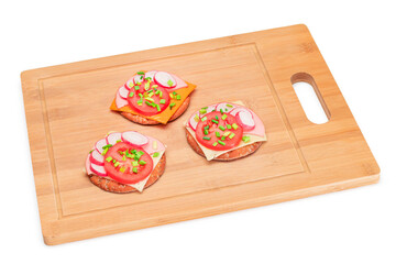 Crispy Cracker Sandwiches with Tomato, Sausage, Cheese, Green Onions and Radish on Cutting Board - Isolated. Easy Breakfast. Quick and Healthy Sandwiches. Crispbread with Tasty Filling - Isolation