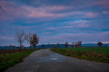 Fototapeta premium Sunrise over the road and fields