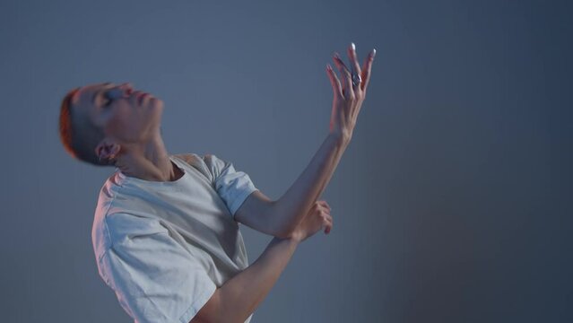 Modern girl with short hair dancing to music in studio. Contemporary conceptual dance. ProRes codec, handheld video