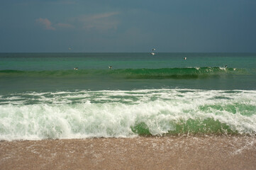 Crystal clear emerald green sea with gold sandy beach. Beach sea area. Natural beautiful landscape view of a tropical beach and green sea on a sunny weather.
