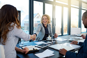 Welcome aboard. Shot of two corporate businesswomen shaking hands during a meeting in the boardroom.