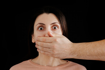 Man hand closes woman mouth, infringement on female rights, gender discrimination. censorship...