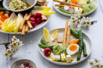 Easter sharing platter with eggs, asparagus, crunchy vegetables and feta