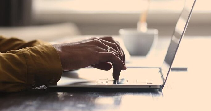 Close up young Black woman sit at work desk type on modern laptop pc device keyboard. Hands of female employee student work on computer write text document search information at internet study online