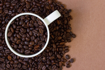 Freshly roasted coffee beans on colored background and cup. 