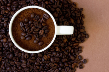 Coffee beans and ground coffee in mug on color background