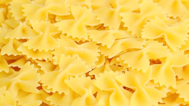 Dry uncooked Italian farfalle pasta rotating close up. High quality 4K footage