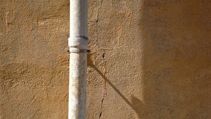asbestos rainwater tube against wall facade