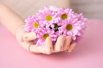 Wooden hand holding beautiful bouquet of violet flowers