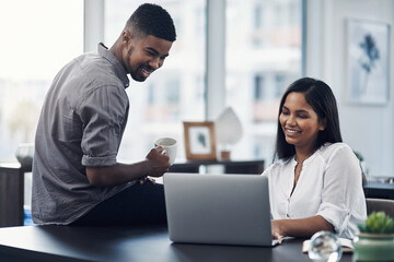 Obraz premium Coming together to source the solutions they need. Shot of two businesspeople working together on a laptop in an office.