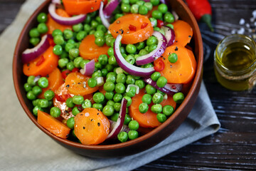 Selective focus. Macro. Healthy salad bowl with green peas, carrots and blue onions. Diet food. Fitness salad.