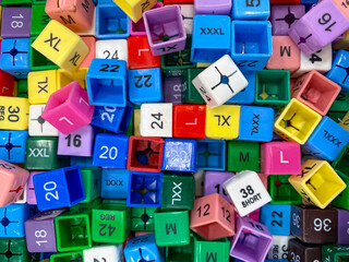 Small, colourful plastic cubes with sizes to put on clothes hangers in shops to tell shoppers the size of the garment.