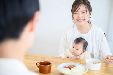 Obraz na płótnie Canvas 赤ちゃんと一緒にご飯をたべるお母さん