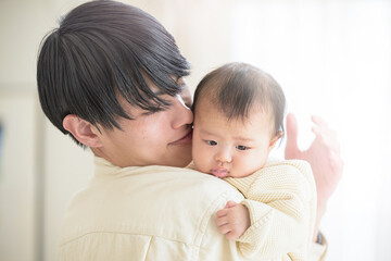 愛情のイメージで使えそうなイクメンのパパと赤ちゃん　手を添える