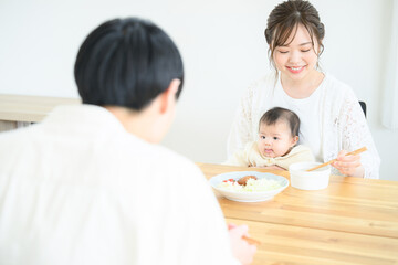 Obraz na płótnie Canvas 食卓で赤ちゃんと一緒にご飯を食べるママさん　笑顔　左にコピースペースあり