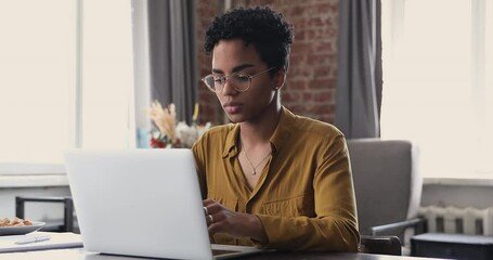 Tired young Black woman worker student take short pause in online work remove glasses massage nose bridge relax with closed eyes. Female employee overworked by pc feel fatigue suffer from eye strain