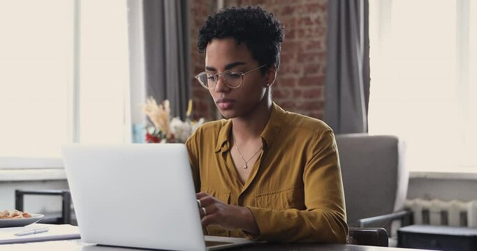 Tired young Black woman worker student take short pause in online work remove glasses massage nose bridge relax with closed eyes. Female employee overworked by pc feel fatigue suffer from eye strain