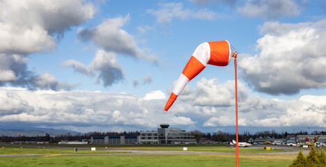 Windsock at an airport with a cloudy sunny sky in background