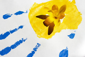 Handprint in the colors of the national flag of Ukraine in blue and yellow on a white background....